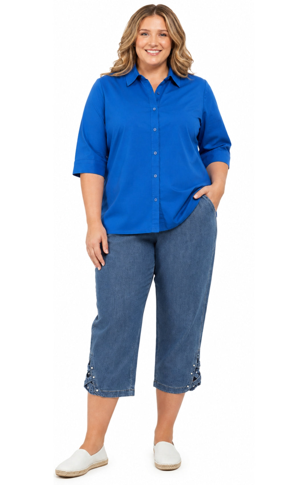 Woman wearing a blue shirt and denim capri pants on a white background